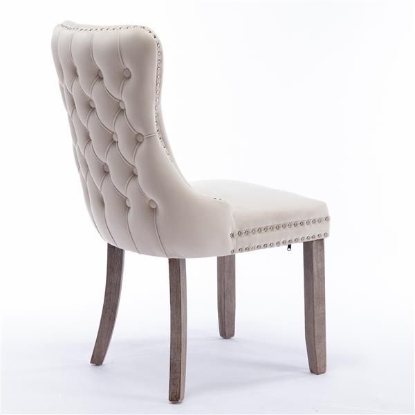 Beige upholstered wingback dining chair nailhead trim detail